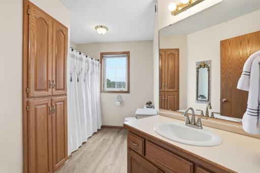 Full upper-level bath with abundant cabinetry, large vanity, and shower/tub combination.
