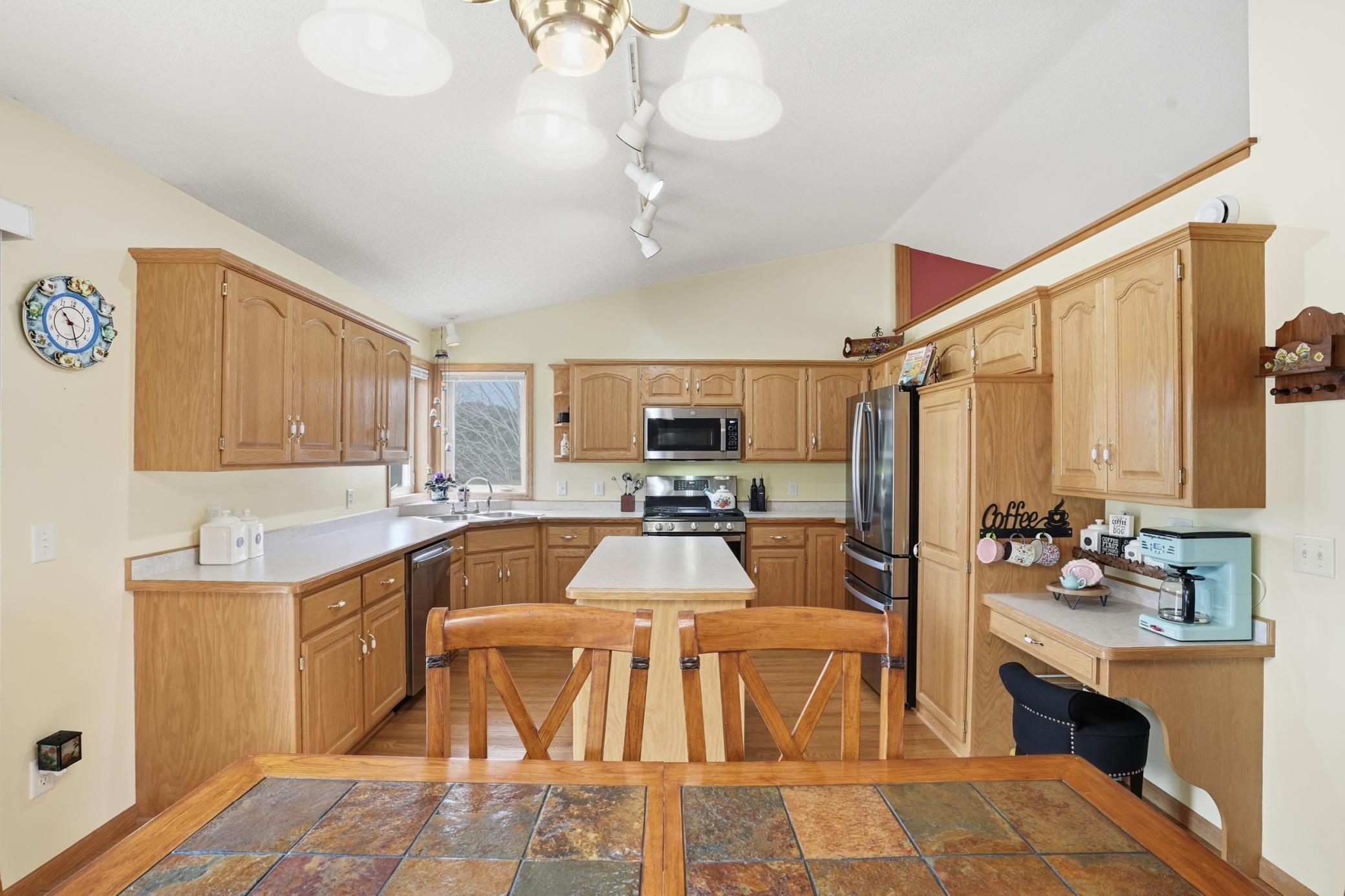 Well-designed kitchen with abundant oak cabinetry, center island, stainless steel appliances, and generous prep space.