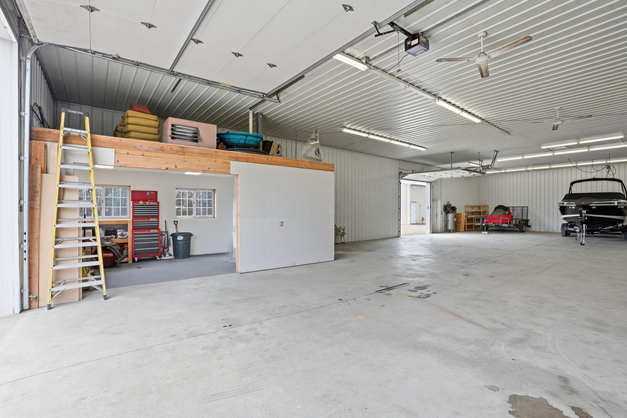 Interior of main shop offers expansive clear-span space, concrete floors, loft storage, and room for multiple large vehicles.