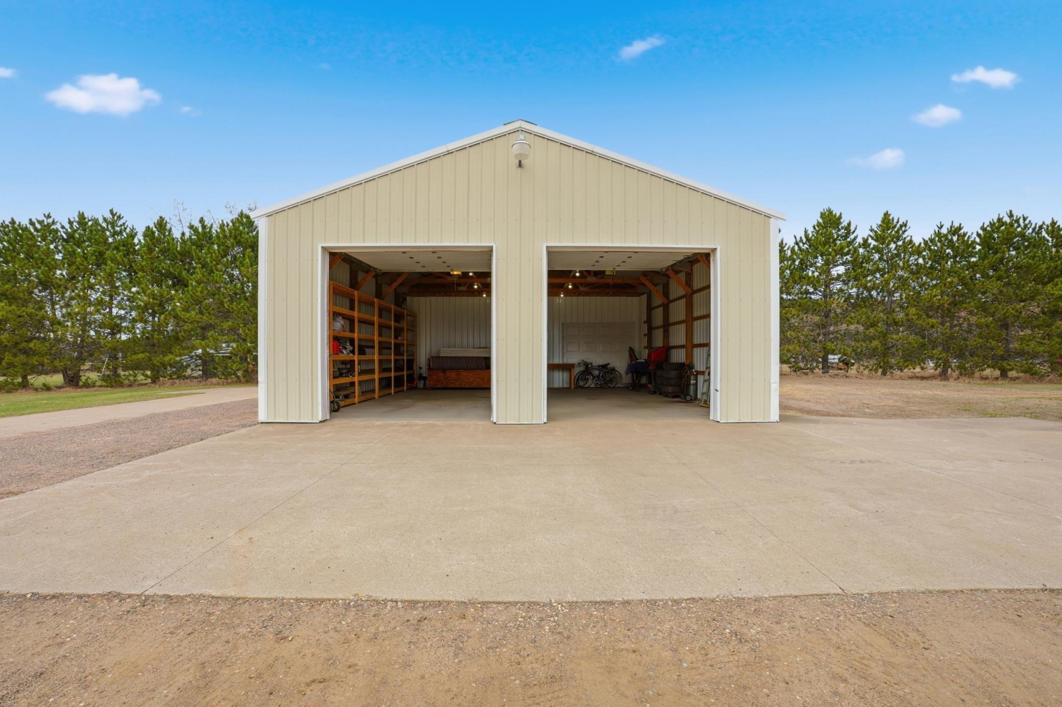 Secondary detached outbuilding provides additional enclosed storage with dual oversized overhead doors.