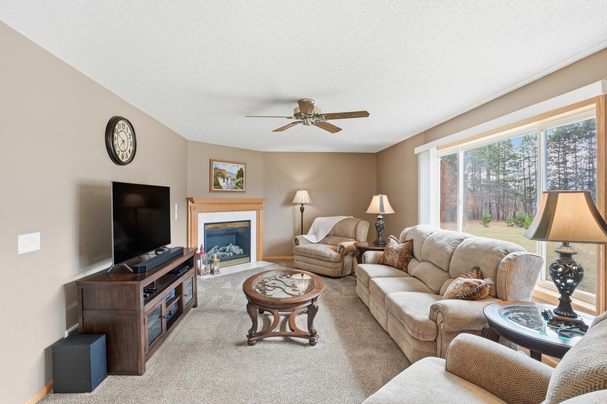 Comfortable main-level family room with fireplace and large windows overlooking the scenic backyard.