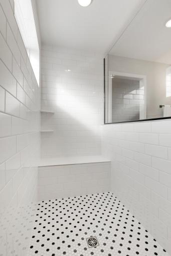 Huge walk-in tiled shower with built-in seating and shelves