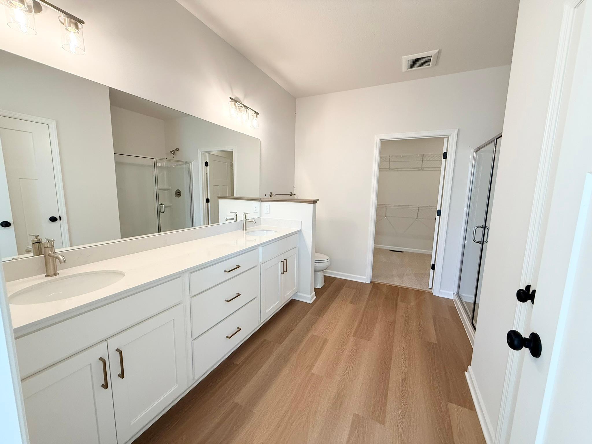 Owner's en suite bath includes double sinks, 5-foot shower stall, and linen closet