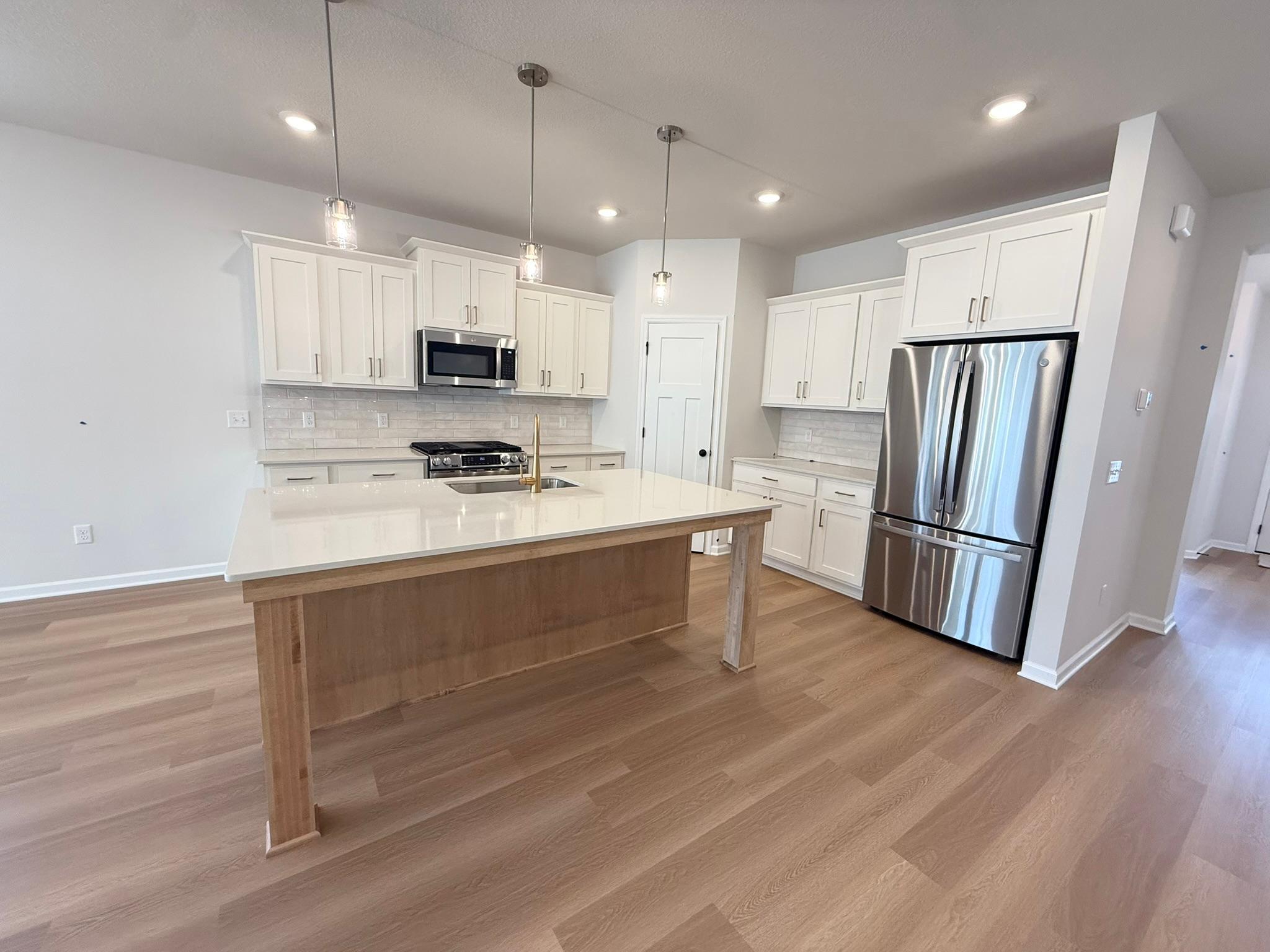 The kitchen features oversized island and upgraded appliances.