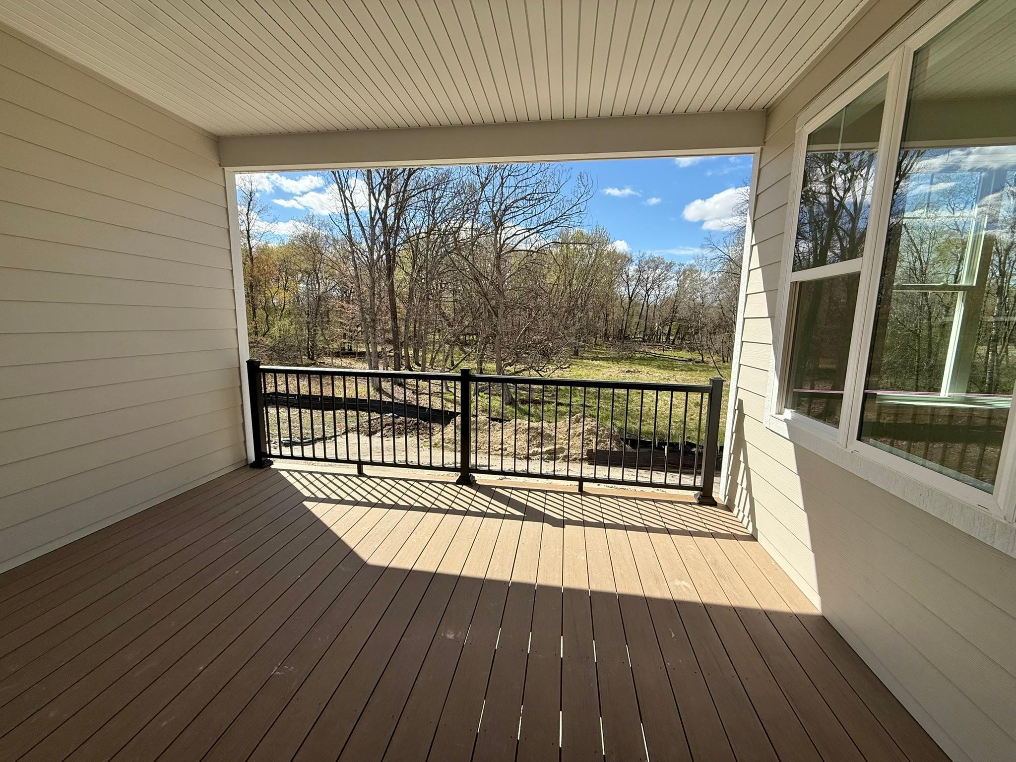 The covered back deck overlooks woods and wetlands