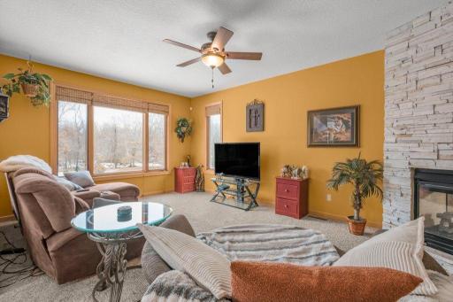 Main floor great room with floor to ceiling, stone, double sided gas fireplace.