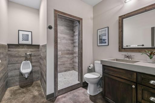 The lower level 3/4 bath continues fun, tasteful aesthetics of the Recreation Room with its custom tile / stone shower & cement vanity top.