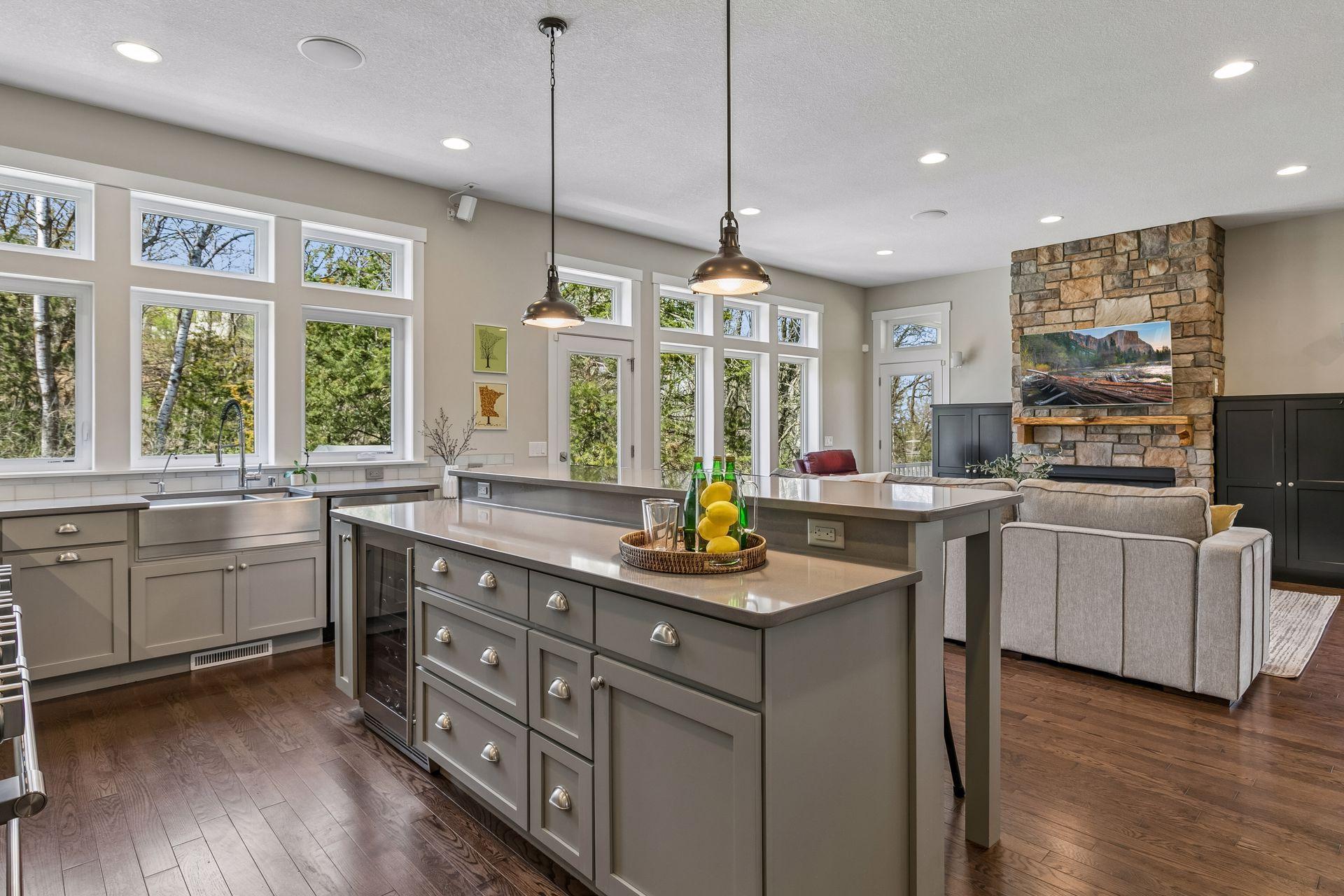 Gather around this center island with an expansive gray quartz countertop, enameled cabinetry & wine cooler.