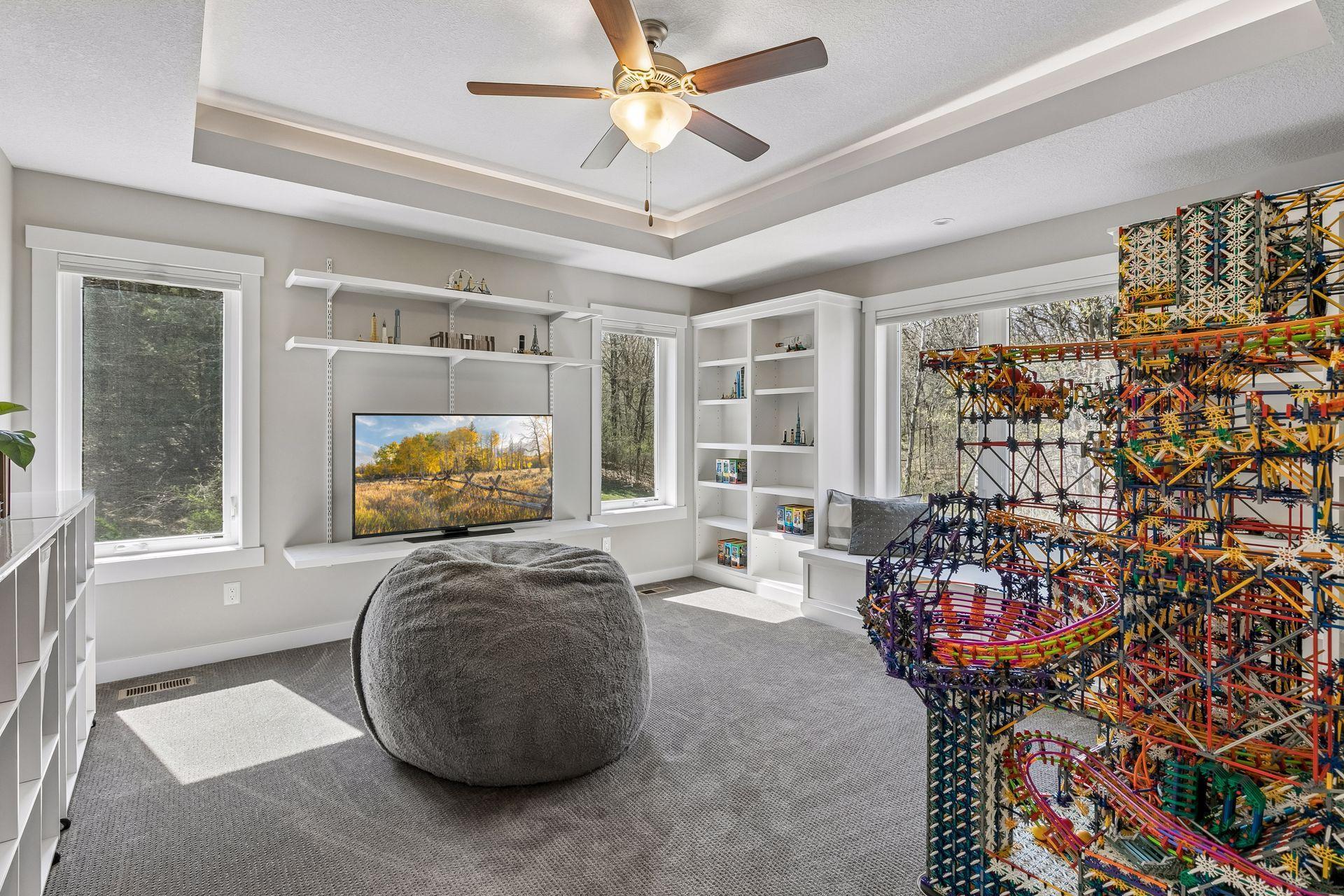 Bedroom 2 on the upper level offers lots of room, built-in shelves, a window seat & tray ceiling with adjutable Hue lighting.
