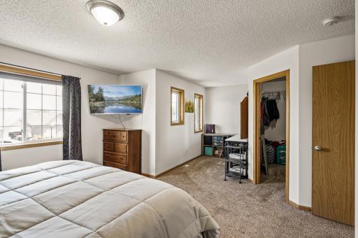 Spacious primary suite with large window for natural light and generous closet space.