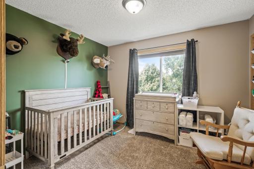 Upper level bedroom with large window and versatile layout ideal for guest room, nursery, or home office.