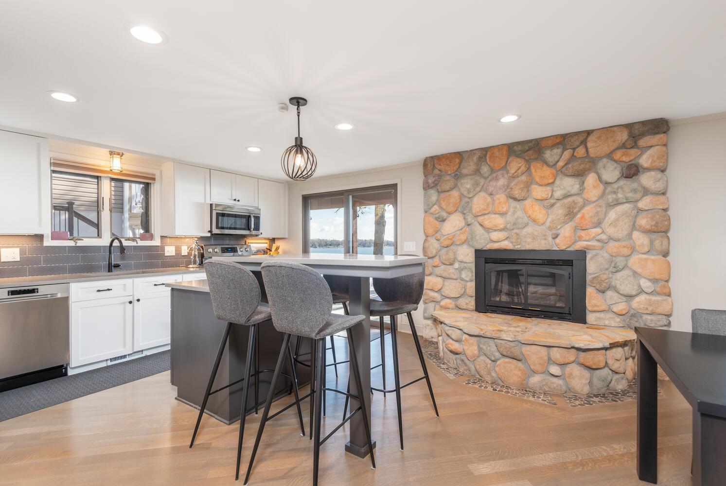 There is recessed lighting, hardwood floors and you can enjoy some informal dining and conversation in front of the stone fireplace!