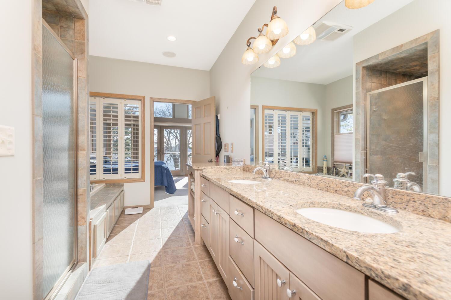 The spacious primary bath with huge double vanity, granite counter and plenty of storage space.