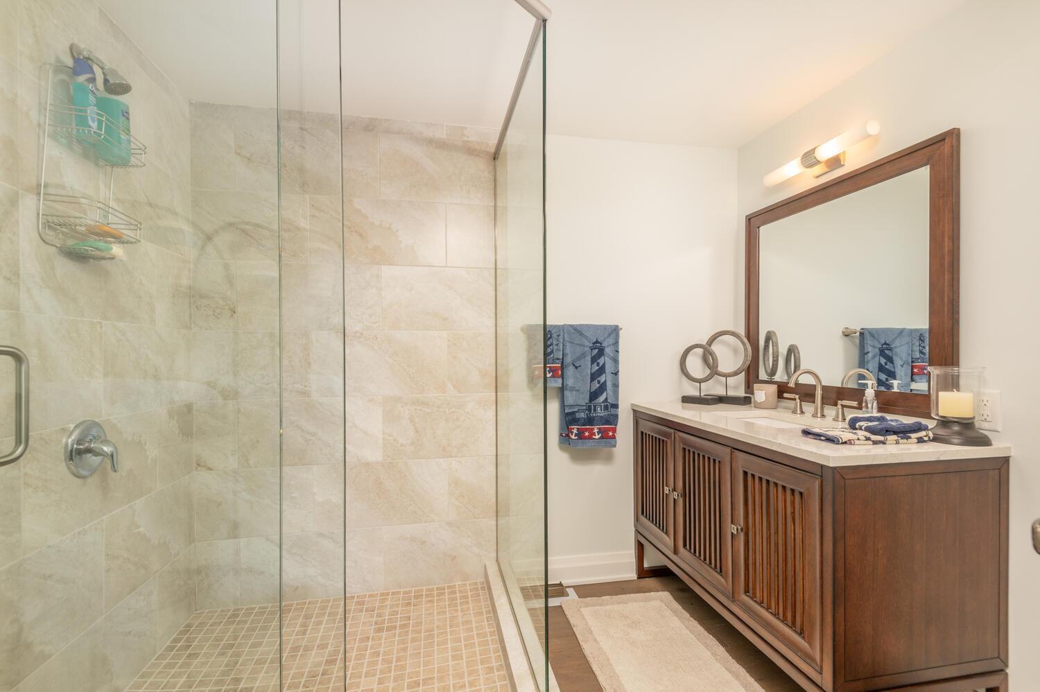 Remodeled lower level bath with spacious tile shower and glass enclosure is so handy when you come in from the lake.