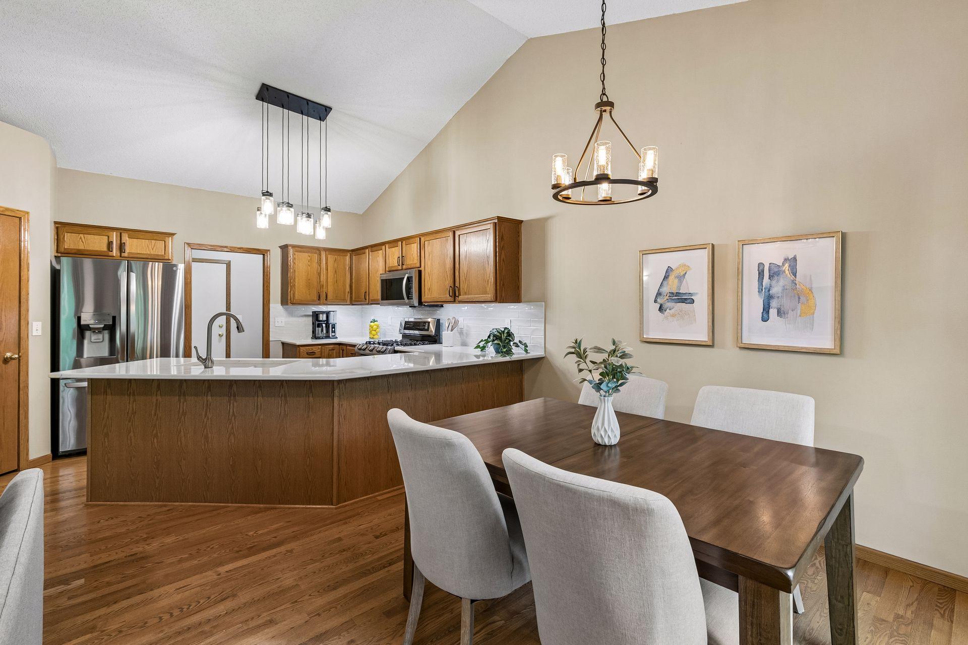Dining area with vaulted ceiling and sliding glass door leading to the private deck overlooking mature trees. Great space for indoor-outdoor living and relaxing with nature views.