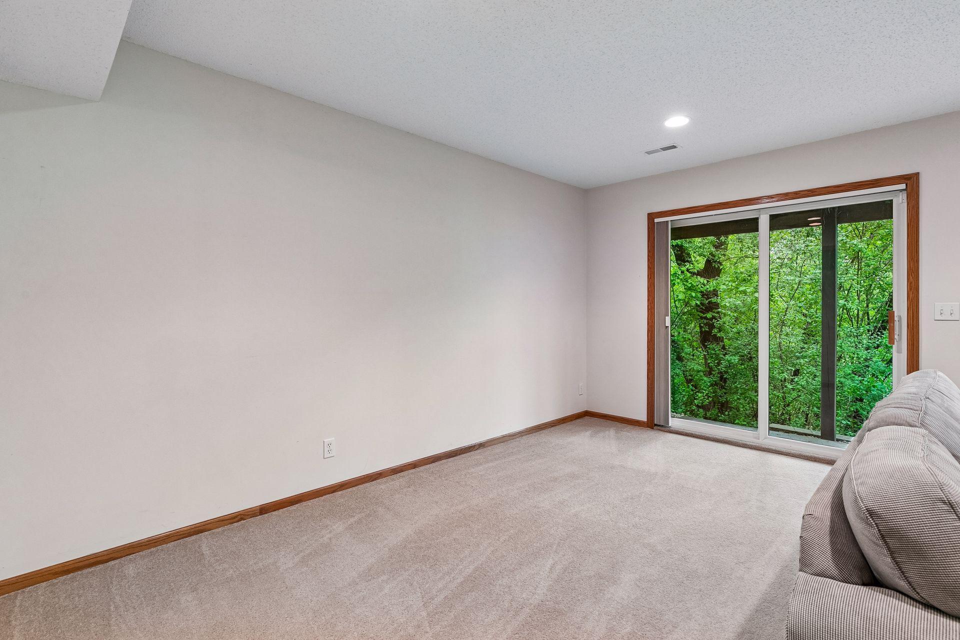 Spacious lower-level family room offering flexible space for movie nights, entertaining, or relaxing by the fireplace.