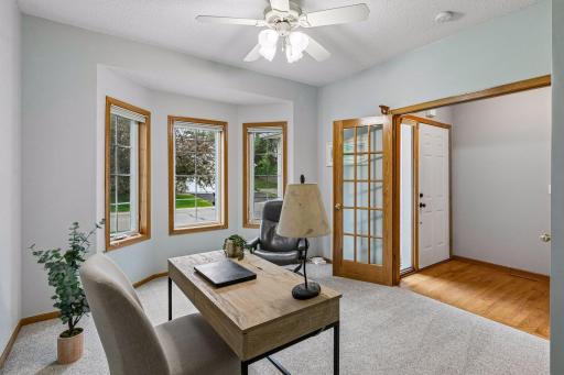 Main-level bedroom currently used as a home office featuring French doors, large bay windows, and abundant natural light. Flexible space ideal for bedroom, office, or guest room.