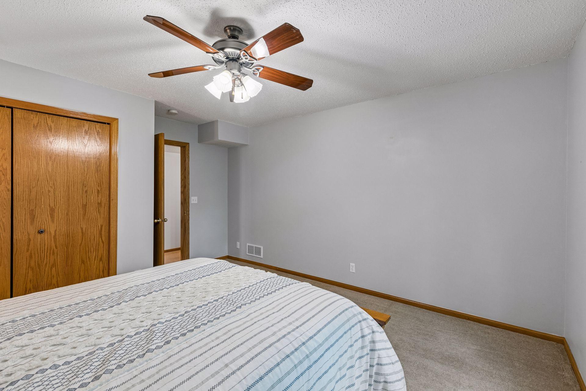 Another view of the lower-level third bedroom featuring generous wall space, neutral finishes, and a functional layout.