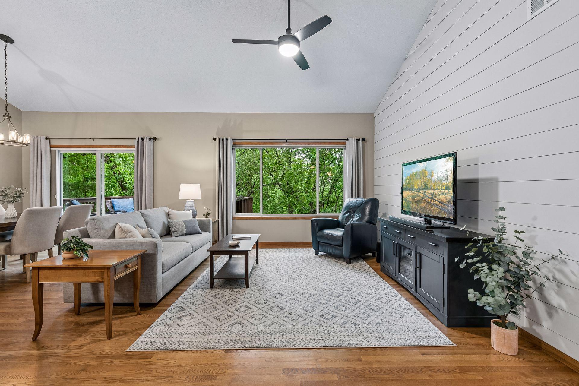 Bright and open main-level living room with vaulted ceilings, large picture windows, hardwood floors and scenic wooded views. Functional layout designed for comfortable everyday living and entertaining.