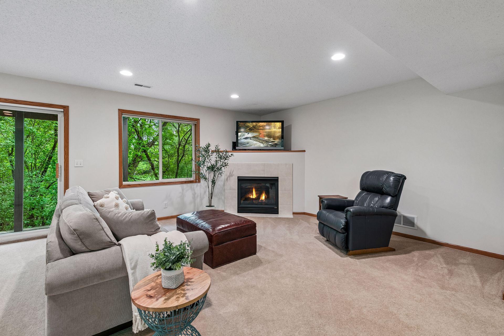 Spacious lower-level family room with cozy fireplace, lookout windows, walkout access, and generous entertaining space. Ideal for movie nights, gatherings, or relaxing evenings at home