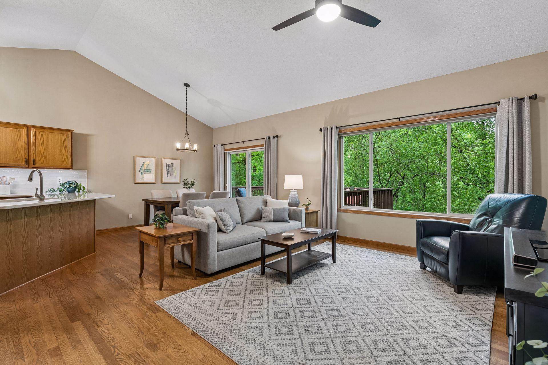 Spacious living and dining area filled with natural light and beautiful backyard views. Main-level layout offers seamless flow between kitchen, dining, deck access and living spaces.