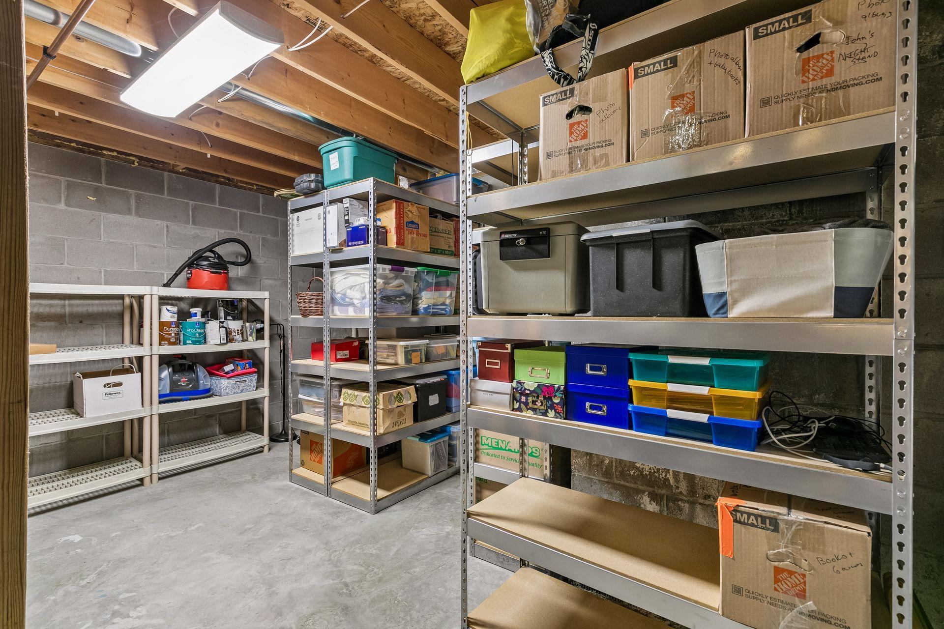 Large unfinished storage room located on the lower level with shelving, concrete floors, and plenty of space for seasonal storage, tools, hobbies, or organization.