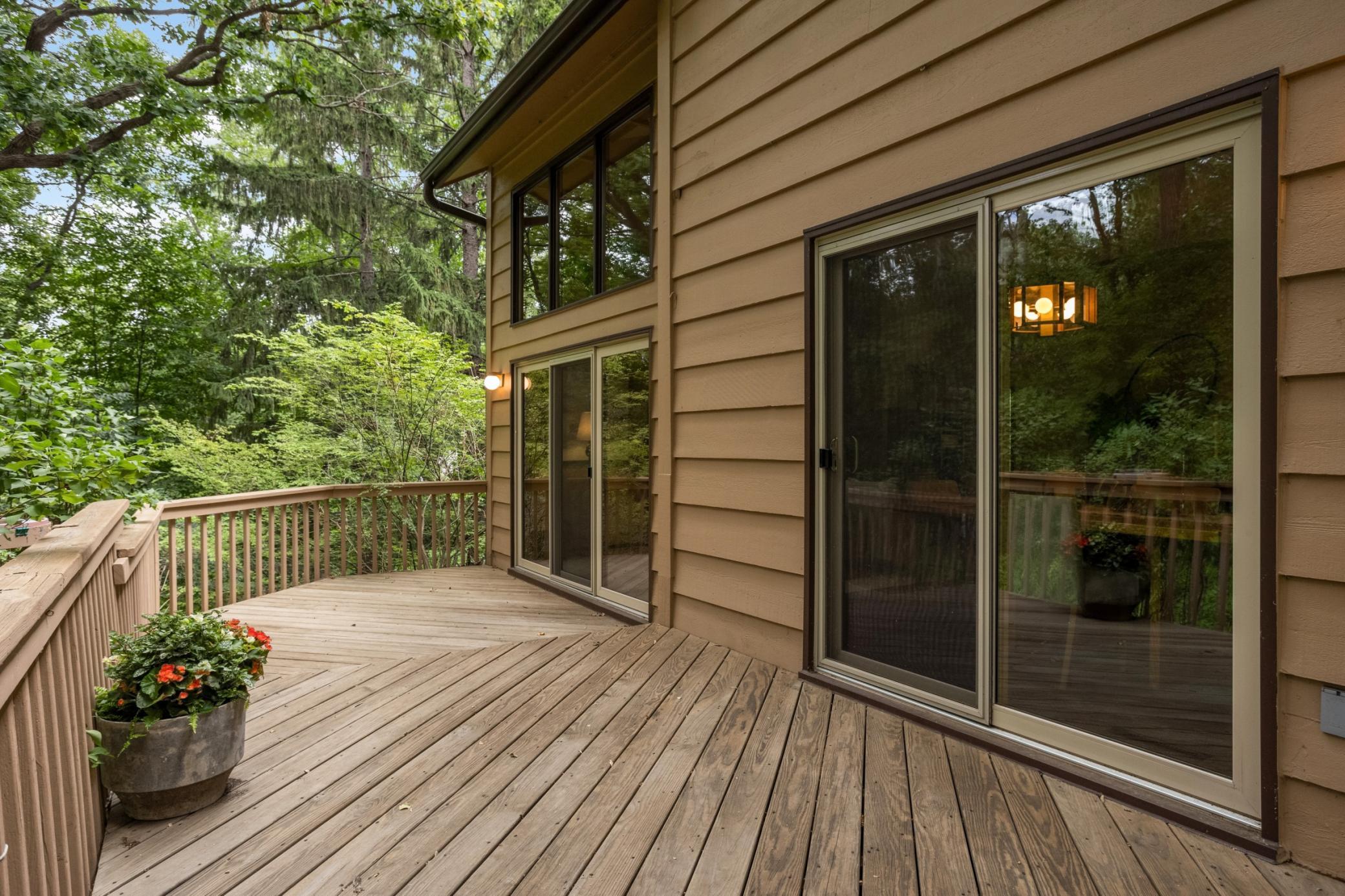 The expansive backyard deck offers plenty of room for entertaining, with convenient access from multiple sliding glass doors and peaceful wooded views.