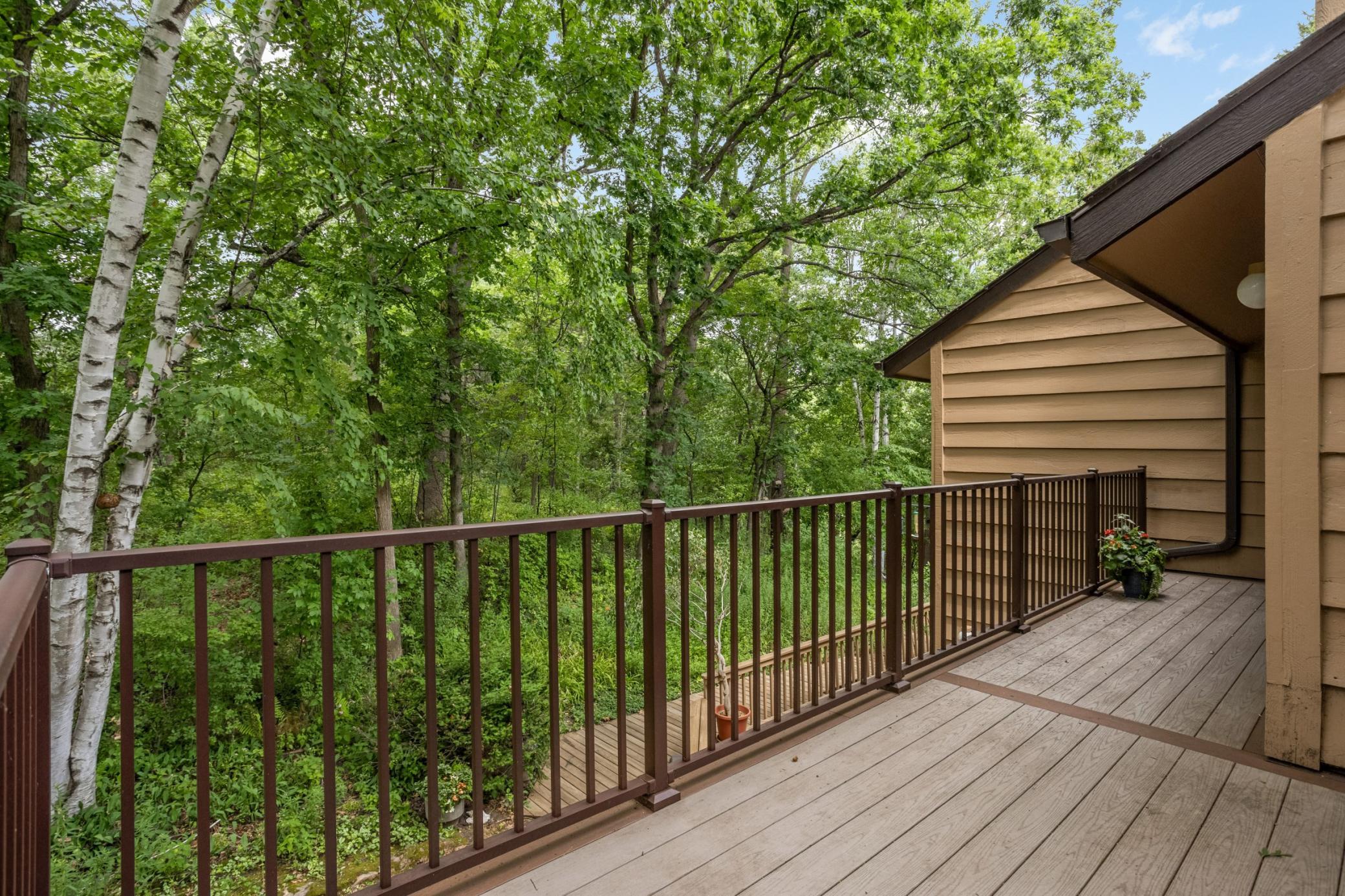 Step directly from the primary suite onto a private wraparound deck surrounded by peaceful, wooded views.