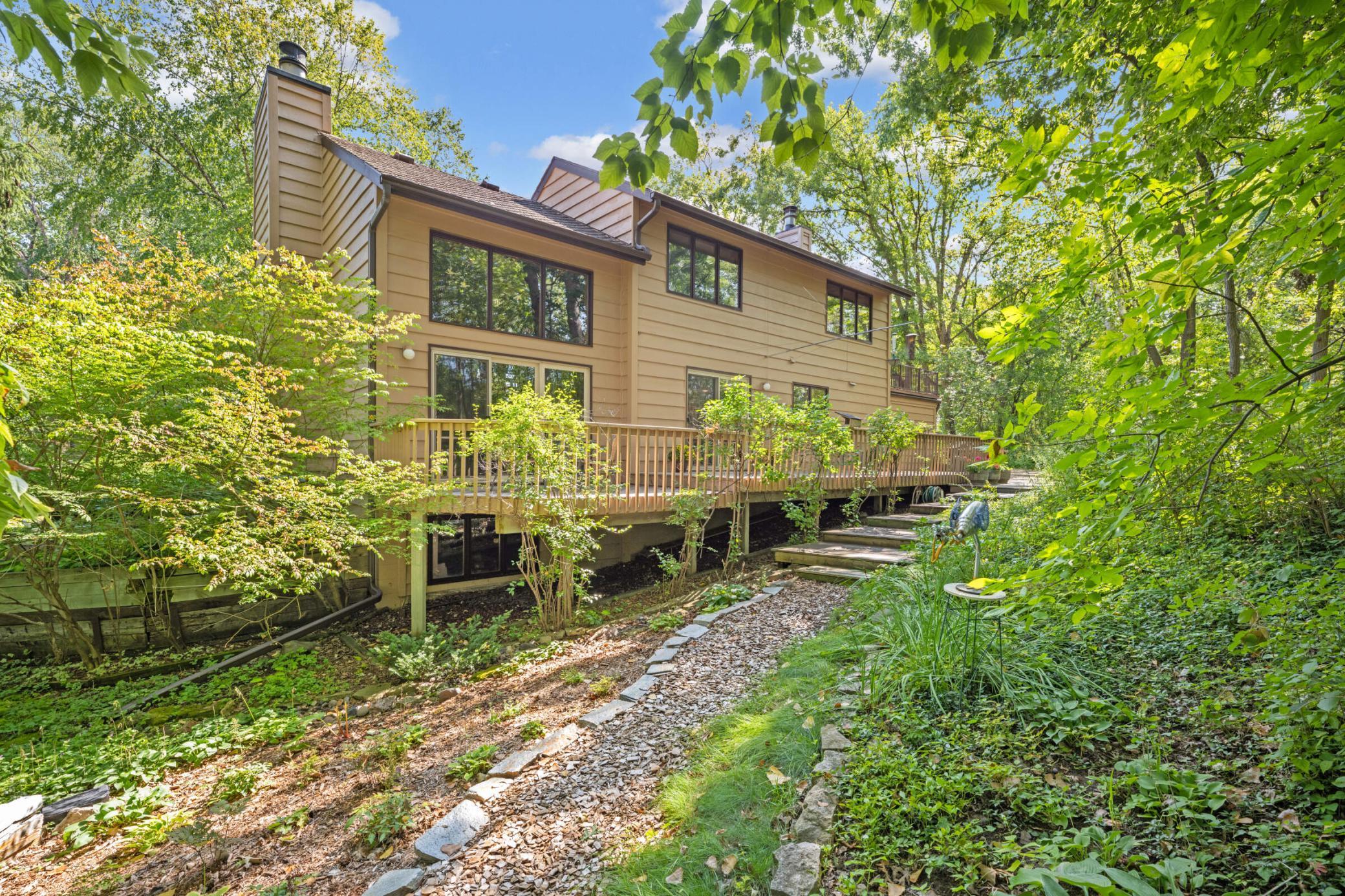 Additional photos from 2022 showcasing the home’s beautifully maintained lawn, mature trees and lush landscaping in full bloom.