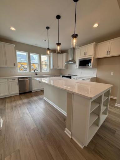 Expansive island with quartz surface offers additional prep space, bar seating, and a stylish centerpiece to your new kitchen.