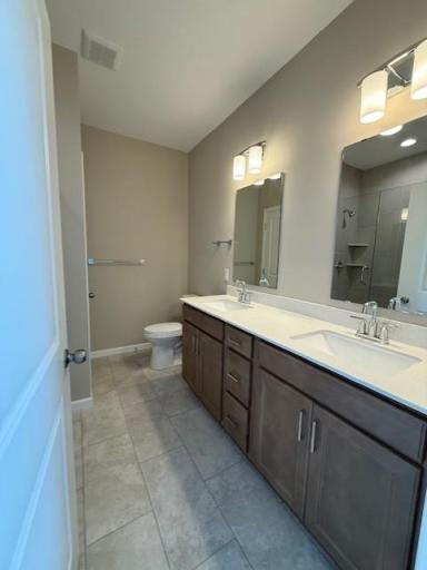 Double vanity with sleek countertops and ample storage provides both function and style—perfect for shared use while maintaining personal space.