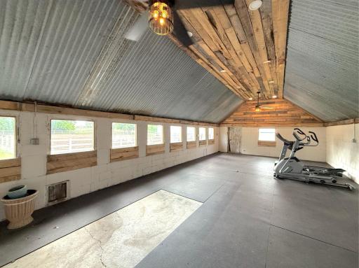 Bathed in natural light from a full wall of windows, the space features durable rubber flooring and an open layout ideal for workouts, training, or wellness activities.