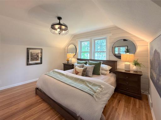 Large windows bring in natural light and stunning country views, while the shiplap accent wall adds character and a cozy touch.