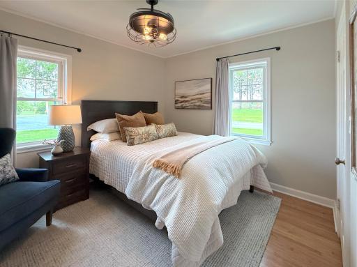 The main level bedroom offers a comfortable and inviting retreat with soft natural light from two windows also offering a view.