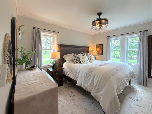 This inviting main-level bedroom features beautiful whitewashed flooring that brightens the space and adds a fresh, modern touch.