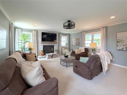 A beautiful stone fireplace with a mounted television creates a striking focal point, perfect for cozy evenings or watching the big game.