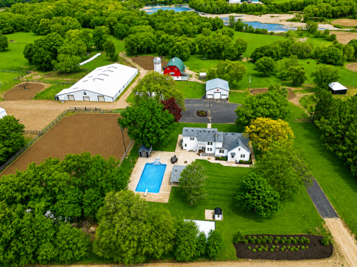The in-ground pool area is complemented by a covered gathering space with a hot tub, creating the perfect setting to unwind or host guests in comfort.