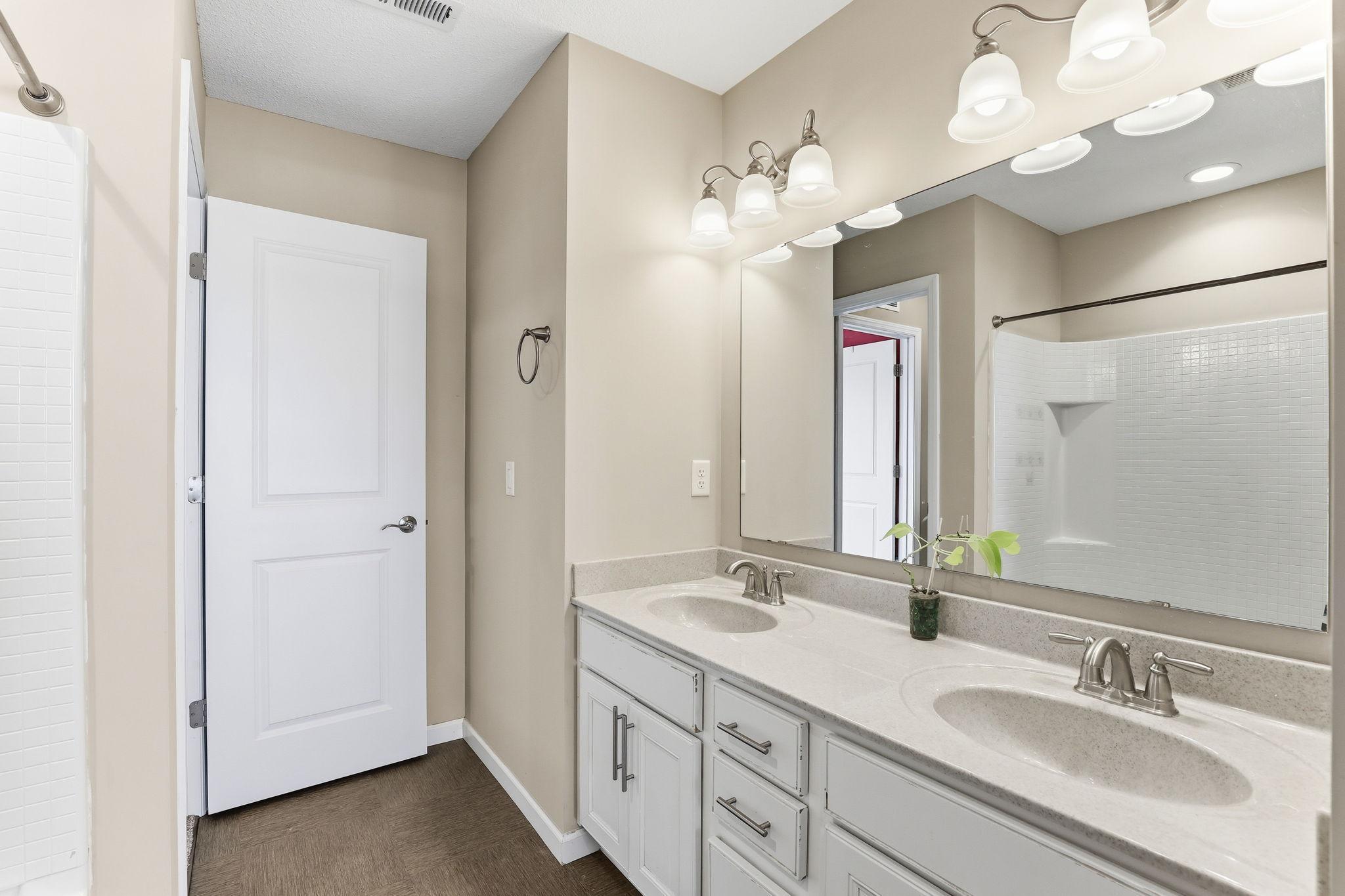 The Jack-and-Jill bath's dual-entry design is clear from this angle. Double sinks and a broad quartz countertop give each user their own dedicated space, and morning routines run smoothly here.