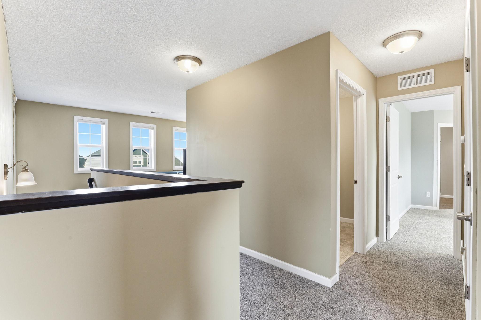 The upper-level hallway connects all four bedrooms and the laundry room. A well-designed floor plan that maximizes daily flow.