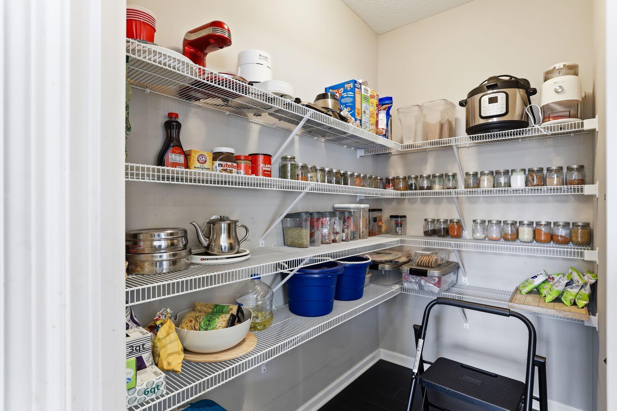 A true walk-in pantry with floor-to-ceiling wire shelving on three walls. The storage capacity here is exceptional, a genuine rarity.