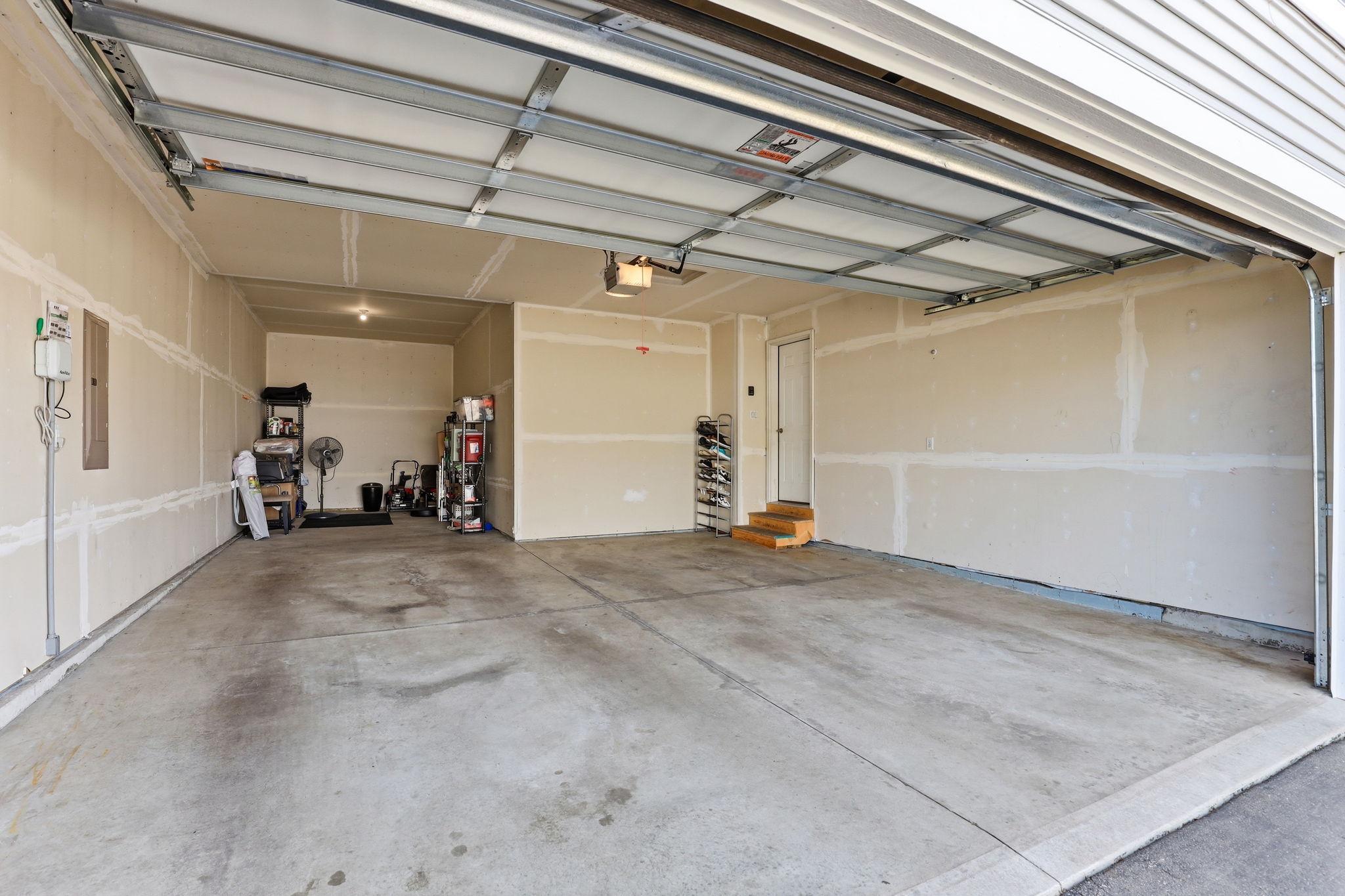 The attached tandem 3-car garage is drywalled, insulated, and smart-connected with a camera-equipped opener. Exceptional depth accommodates three vehicles plus workshop or dedicated storage space.