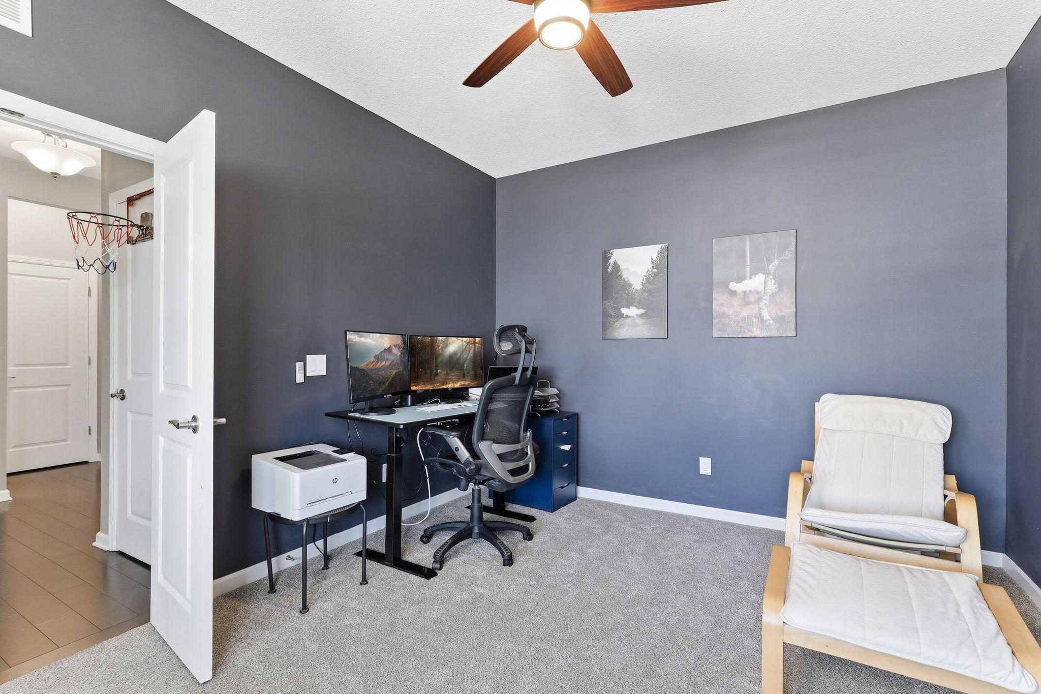 The main-floor flex room adapts to whatever you need most: home office, homework hub, or study. A ceiling fan, carpet, and a large window make this space practical and comfortable.