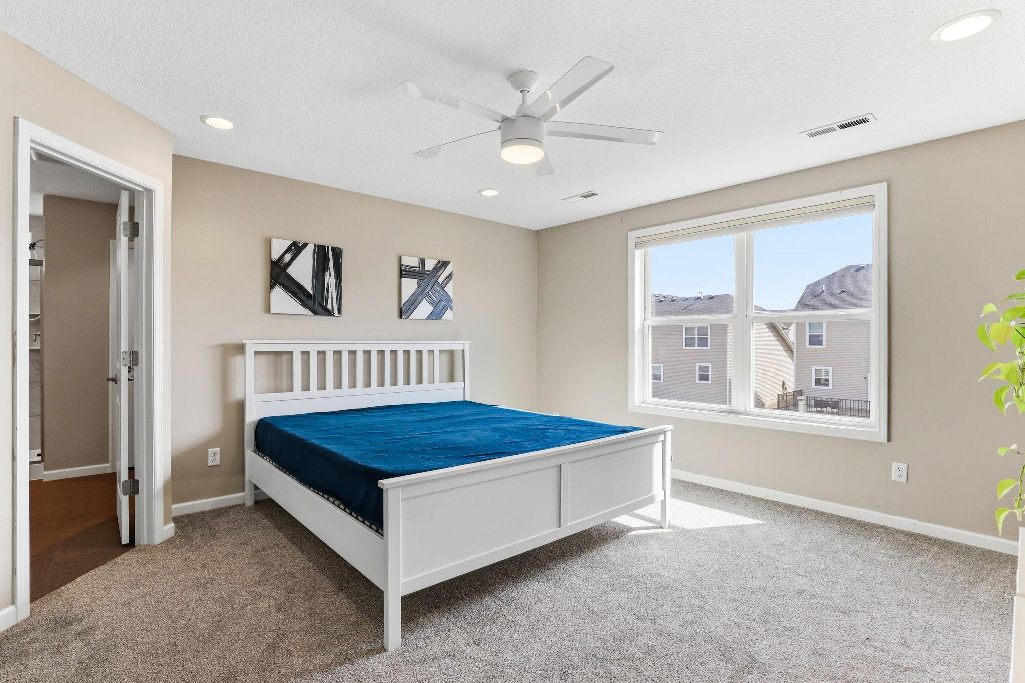 The primary suite delivers quiet scale and comfort: recessed lighting, a ceiling fan, plush carpet, and generous proportions that adapt effortlessly to any bedroom configuration.