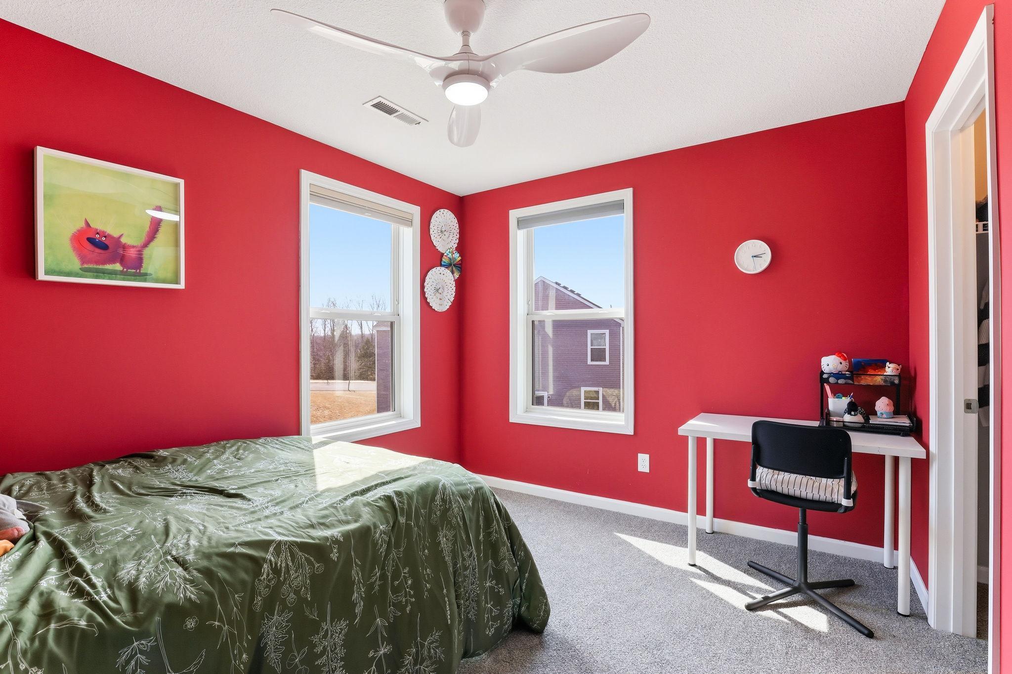 Crisp carpet, a ceiling fan, and dual windows fill this freshly painted upper-level bedroom with light. A lively palette and generous proportions make this room instantly memorable.