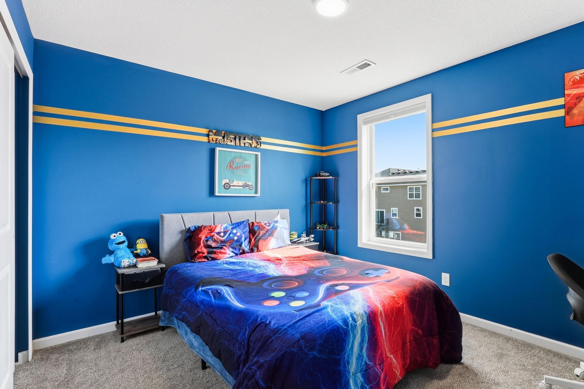 A well-sized secondary bedroom with plush carpet and a bright window. Bold paint and personality today, a clean canvas for any buyer's vision tomorrow.