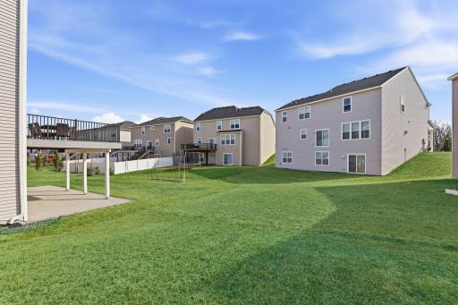 A lush, well-maintained backyard with in-ground sprinklers, a lower paver patio, and a composite deck above. Room to play, room to entertain, and a neighborhood setting that delivers community.