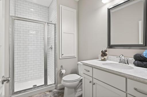 Enjoy a beautifully finished bathroom with tiled walk-in shower and linen cabinetry.