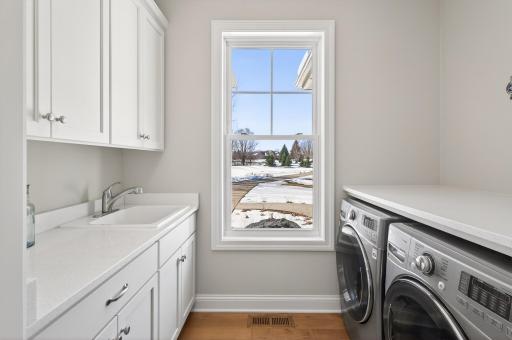 Attached, designated laundry area with counterspace, plenty of storage, and a sink.