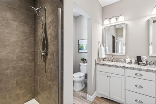 The ensuite features a tiled walk-in shower, double vanity, and abundant storage.