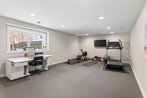 An extra-large fifth bedroom, originally designed to accommodate a 12 ft longarm quilting machine, functions perfectly as a bedroom, fitness area, hobby space, or creative studio.
